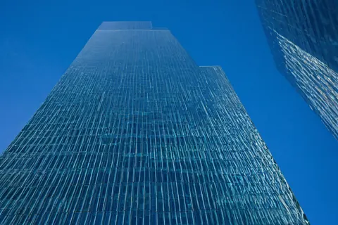 Towering glass skyscraper against a clear blue sky